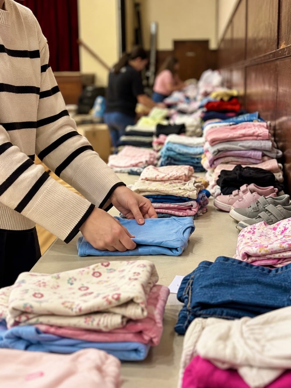 Morning Star Christian Church volunteers in Boise folding and laying out donated children’s clothes for the single mothers ministry