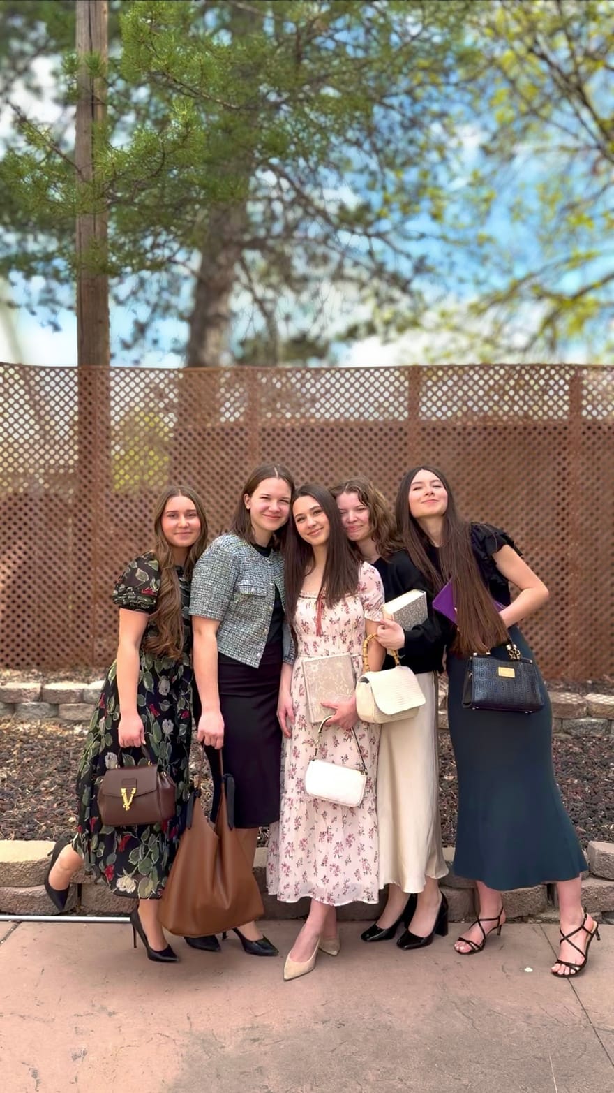 Morning Star Christian Church youth group. Five teens dressed up arm-in-arm at a Friday Youth Service event in Boise, Idaho, evening backdrop of trees and fencing.